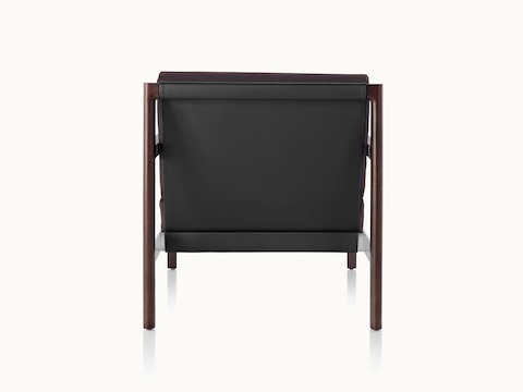 A Brabo club chair with a black leather sling, metal accents, and an exposed wood frame, viewed from behind.