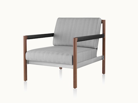 A Brabo Club Chair with light gray upholstery, leather and metal accents, and an exposed wood frame. Viewed at an angle.