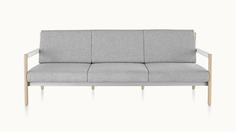 A Brabo sofa with light gray upholstery, white leather-wrapped arms, metal accents, and a light wood frame, viewed from the front.