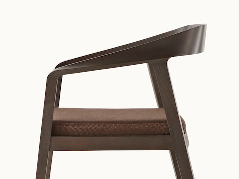 Side view of a Full Twist Guest Chair with a dark wood frame and a brown upholstered seat pad. Select to go to the Side Chairs landing page.
