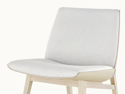 Angled view of a low-back Clamshell Lounge Chair with off-white fabric upholstery and light-ash legs.