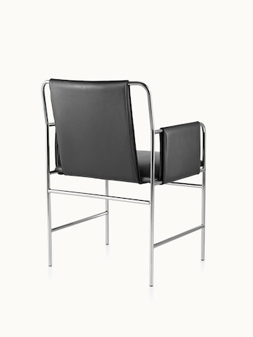 An Envelope side chair with black leather upholstery and a tubular steel frame, viewed from behind at an angle.