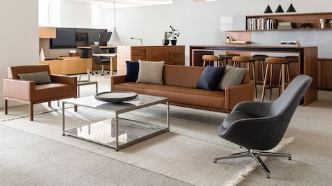 An open office space featuring a sitting area that includes Wood Base Lounge Seating and an H Frame coffee table with stone upper and lower surfaces.