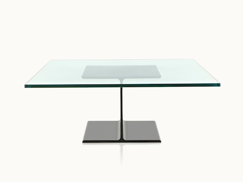 A glass-top I Beam coffee table, with the upper and lower flanges of the cast-aluminum pedestal viewed in profile.