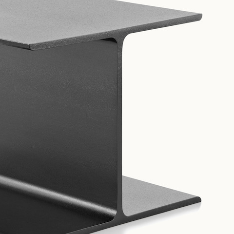 Close-up of the black cast-aluminum base of an I Beam occasional table.