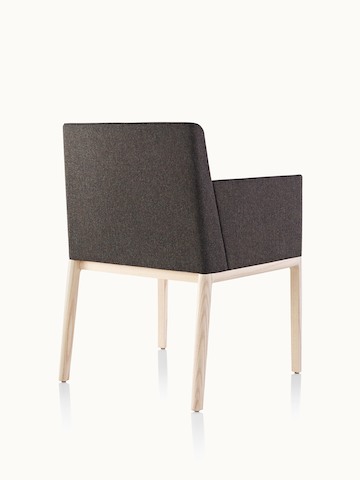 A Nessel side chair with black fabric upholstery, wraparound arms, and a wood frame with a light finish, viewed from behind at an angle.