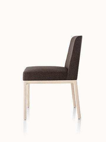 Side view of an armless Nessel side chair with black fabric upholstery and a wood frame with a light finish.