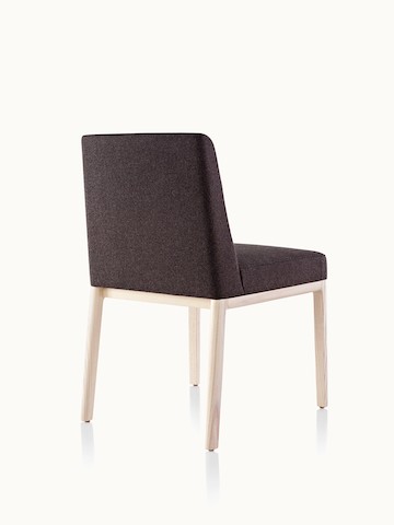 An armless Nessel side chair with black fabric upholstery and a wood frame with a light finish, viewed from behind at an angle.