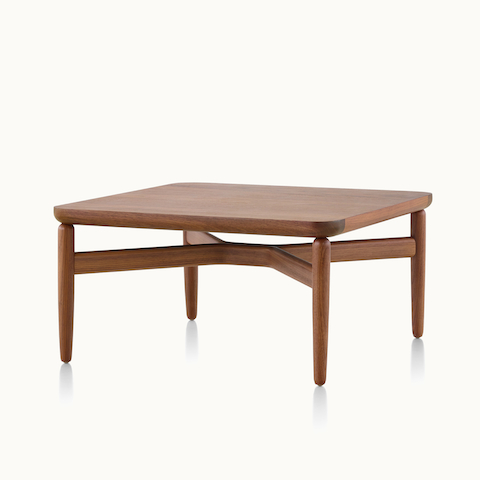 Angled view of a rectangular Reframe occasional table with a medium wood finish. Select to go to the Reframe Tables product page.