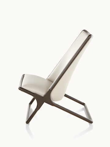 Side view of a Scissor lounge chair with ivory-colored leather upholstery and a wood frame in a dark finish.