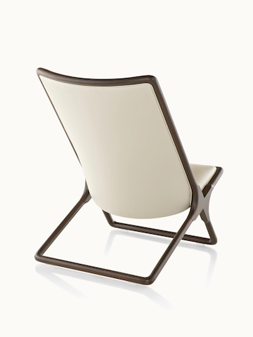 A Scissor lounge chair with ivory-colored leather upholstery and a wood frame in a dark finish, viewed from behind at an angle.