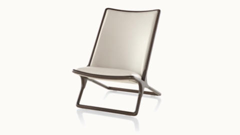 Angled view of a Scissor lounge chair with ivory-colored leather upholstery and a wood frame in a dark finish.