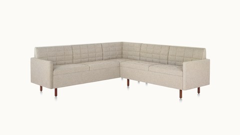 A quilted Tuxedo Classic sectional upholstered in bone-colored fabric.