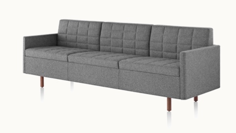 Angled view of a Tuxedo Classic sofa with dark gray quilted upholstery.