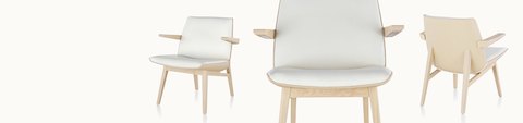 Three low-back Clamshell Lounge Chairs with a light veneer shell and white leather upholstery, positioned at different angles.